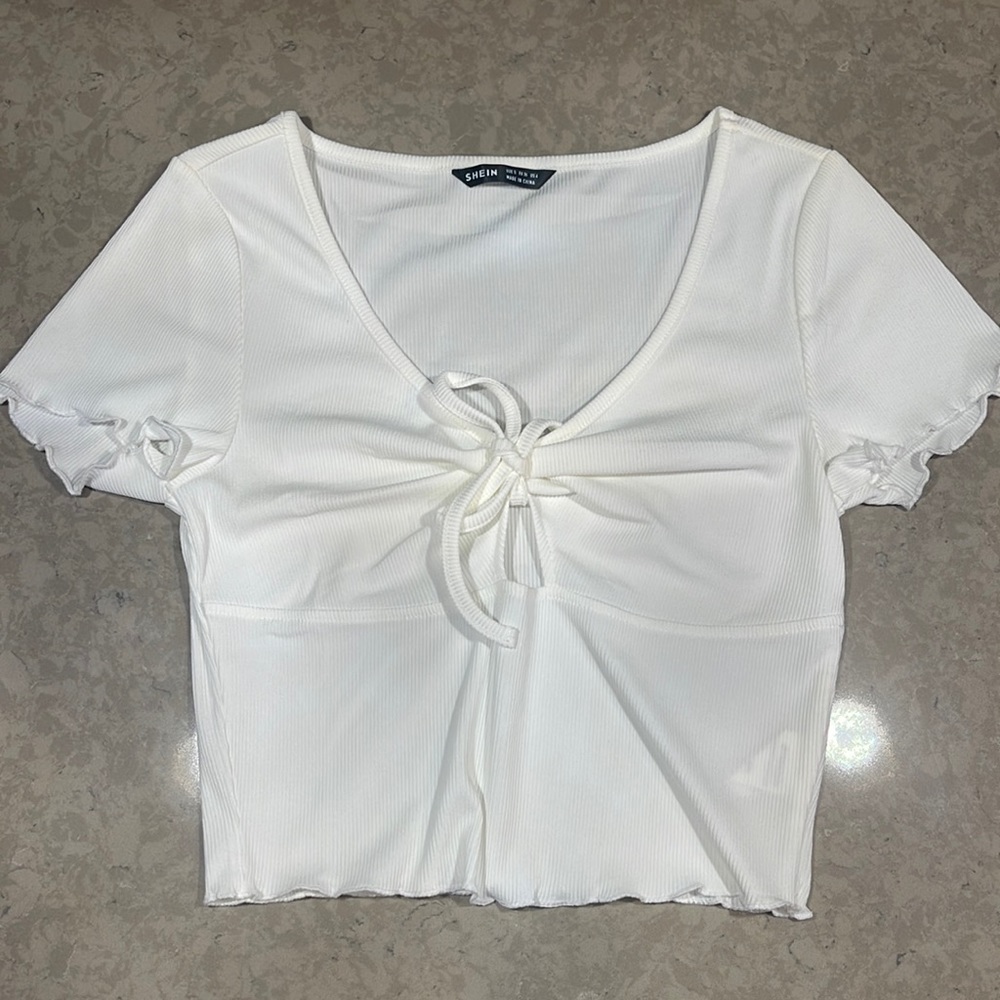 A plain white cropped shirt size 4. It has a little cut out in the front.
